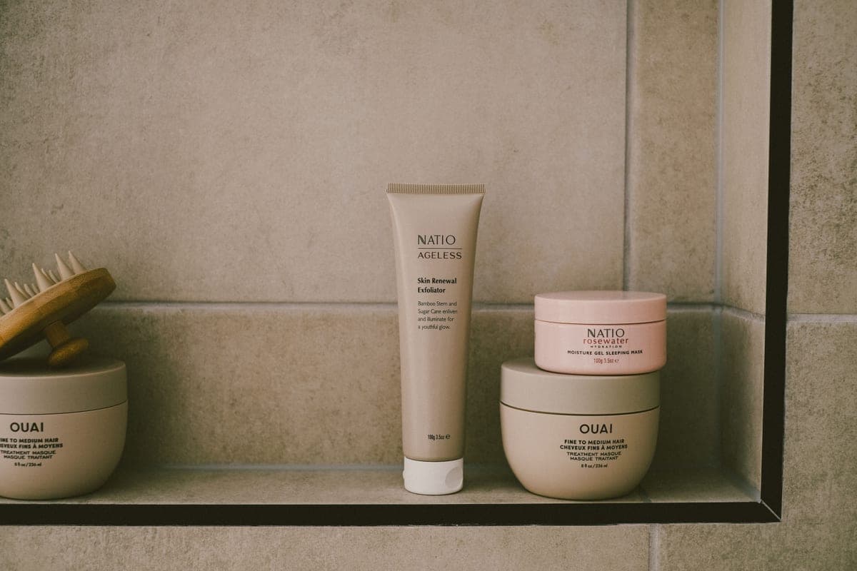 Face sunscreen tube on a bathroom shelf beside morning skincare