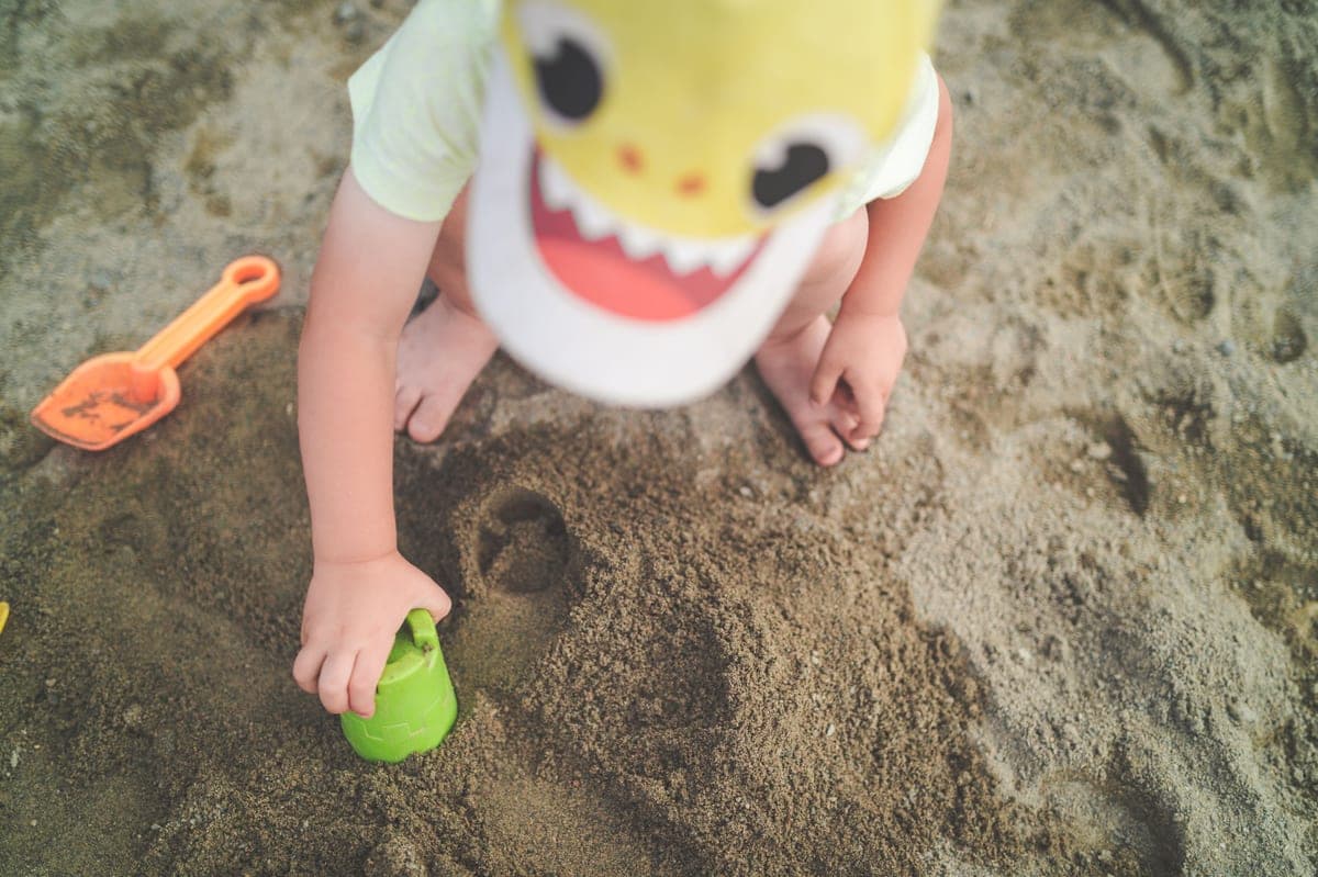 Sunscreen stick being applied to a child's cheek at the beach