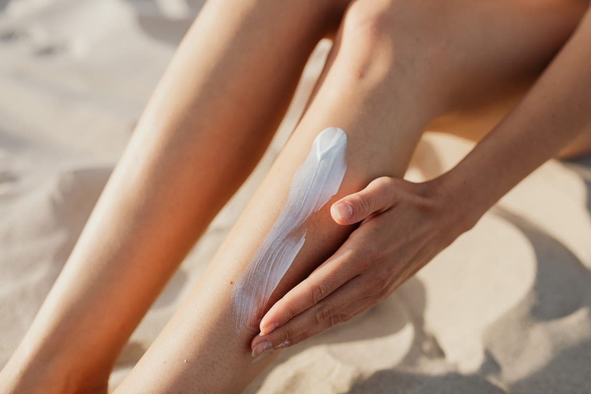 Sunlight falling across a forearm with sunscreen being spread on it