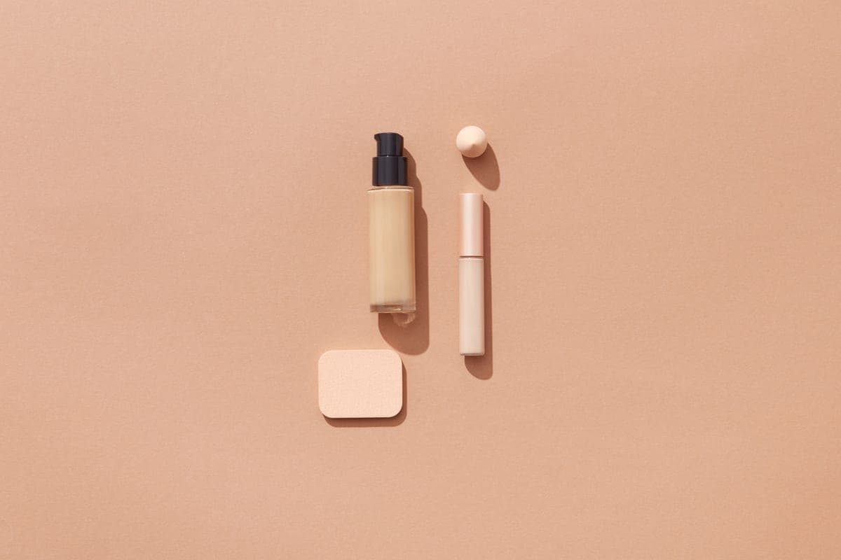 Tinted sunscreen and a foundation bottle side by side on a vanity