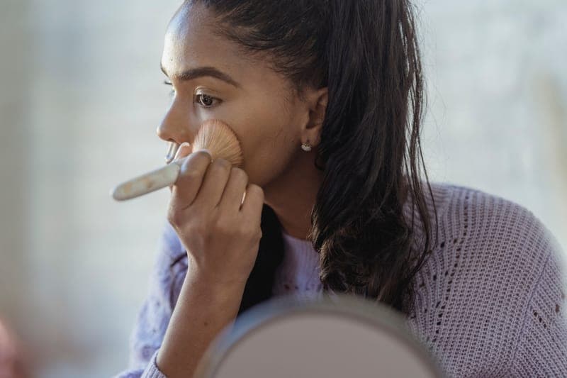 Tinted BB cream with SPF beside a makeup brush