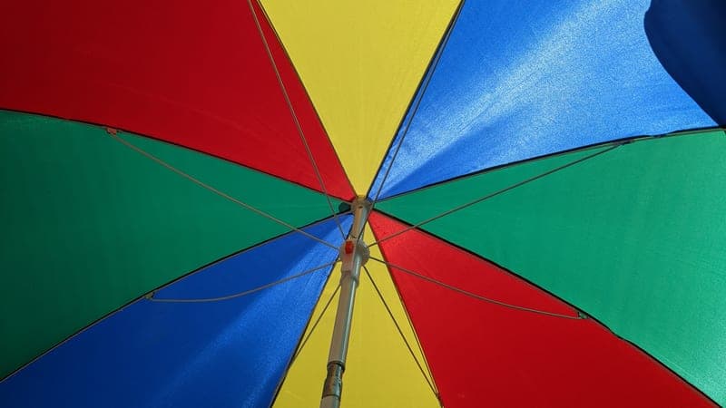 Clamp-on shade umbrella angled over a folding chair