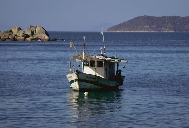 Angler in a hooded sun shirt standing on the water