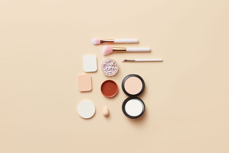 Powder sunscreen brush applicator on a marble surface
